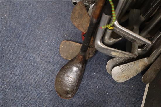 A collection of golf clubs, including woods and irons (makers including Whitcombe and Spalding)